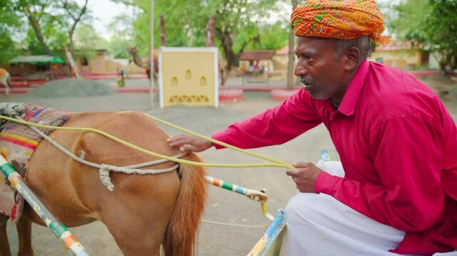 Turbaned rider gently strokes steed from behind