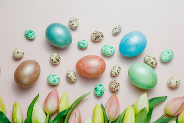 Easter eggsin basket on pink background with tulips.