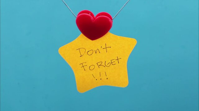 Clip holding a sticky note with a don't forget phrase