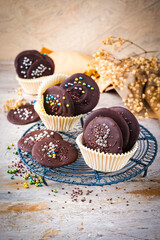 Artisan homemade fine dark chocolate thaler  decorated with colorful sugar pearls in muffin moulds