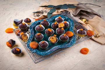 Artisan homemade pralines with dried apricots, fruits and nuts,  coated with fine bitter dark...