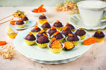 Artisan homemade pralines with dried apricots, fruits and nuts,  coated with fine bitter dark...