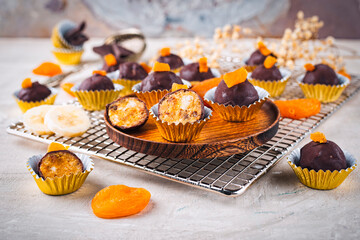 Artisan homemade pralines with dried apricots, fruits and nuts,  coated with fine bitter dark chocolate