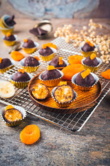 Artisan homemade pralines with dried apricots, fruits and nuts,  coated with fine bitter dark...