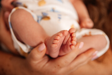 Tender moment of a baby’s tiny feet held in loving hands, ideal for family, newborn, or parenting themes.