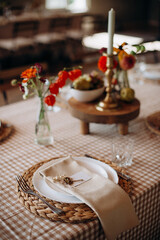 Rustic outdoor place setting with a checkered tablecloth and dried flowers