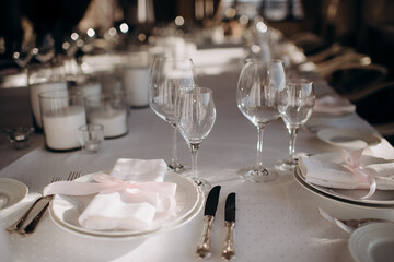 Elegant indoor table setting with a pink ribbon on the napkin