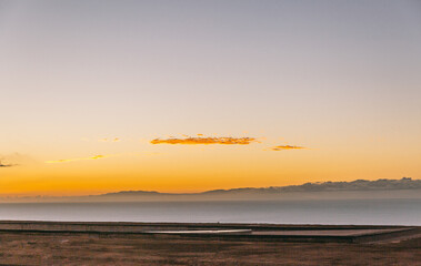 Obraz premium The sky is a beautiful orange color, and the ocean is calm