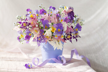 Still life with a bouquet of spring and summer blue, pink, white and purple flowers, columbine, pansies, forget-me-nots. Beautiful card