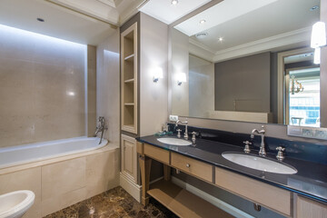 Bathroom with a classic design, in warm pastel colors. Retro style faucets, a large mirror over the...