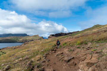 Fototapeta premium Hiker Walking Along Scenic Cliffside Trail by the Ocean