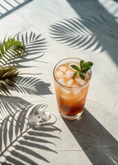 Palm leaves shadow over cold drink on table