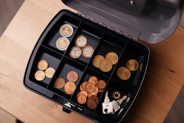 Open coin box with euro and cent coins, illustrating savings, budgeting, or cash-handling concepts.