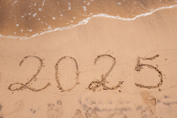 The year “2025” written on the beach near foamy waves—perfect for New Year’s themes, resolutions, or travel into the future.