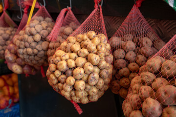 Special small tasty potatoes papas negras on market hanging in nets, main dish on Canary islands, Spain, cooked with salt and served with mojo sauces