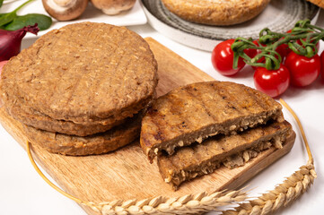 Round vegetarian patties or burgers made from grains, vital wheat gluten food, uncooked and grilled