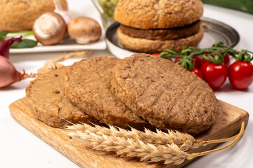 Round vegetarian patties or burgers made from grains, vital wheat gluten food, uncooked and grilled