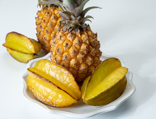 Two whole fresh ripe pineapples or sweet baby ananas on white background close up