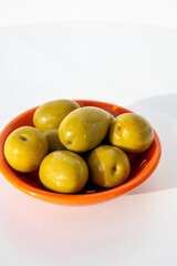 Homemade pickled big green olives in bowl, spanish tapas close up