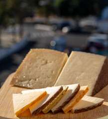 Assortment of Spanish hard cheeses, curado, manchego, goat cheese served for tasting, close up