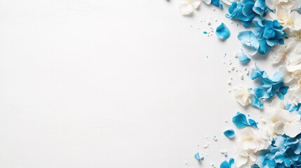 Fototapeta premium Blue and white hydrangea petals scattered on a clean white background, creating a decorative side border with copy space.