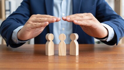 Businessman covering wooden figures of people. Employer commitment to protecting the human rights, labor rights, and providing support and insurance to employees within the community.