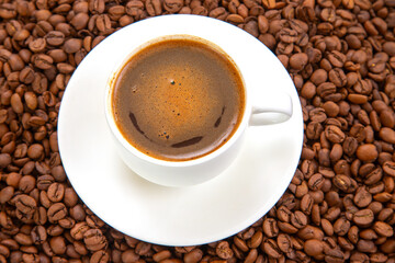Rich, dark espresso with a frothy crema in a white ceramic cup, elegantly placed on a saucer amidst scattered coffee beans, creating a warm, inviting coffee scene