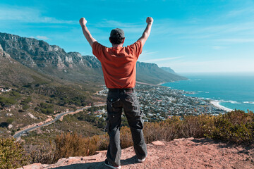 Top of the world - Victory and success. Cape Town hiker reaches summit of Lions Head, Table Mountain. South Africa is best travel and tourism destination for adventure and nature