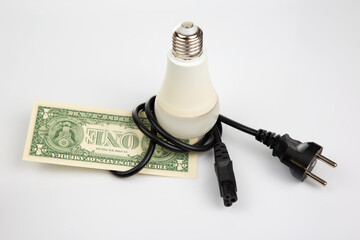 Dollars, LED lamp and electric cable plug. Saving electricity. Energy saving concept