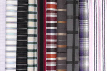 Multi-colored fabric layers with plaid and stripe patterns, ideal for fashion or interior decor...