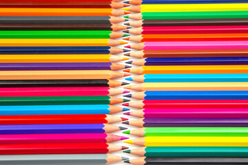 Sharpened multicolored pencils in a grid pattern. Suitable for art supplies, educational materials, or creative stationery imagery.