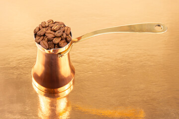 Classic Turkish coffee maker in copper with a long brass handle, surrounded by coffee beans on a...