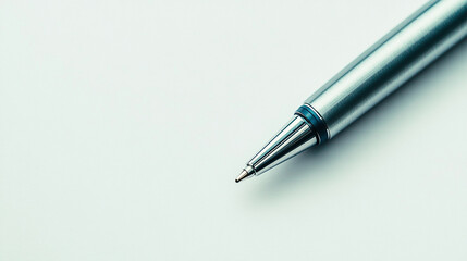 Silver ballpoint pen lying diagonally on a white sur