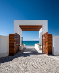 White-walled entrance gate with wooden accents against a blue sky and sea in Archdaily style