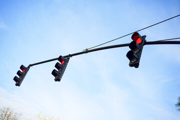 Red Traffic Lights Against Blue Sky
Multiple red traffic lights suspended from a horizontal pole,...