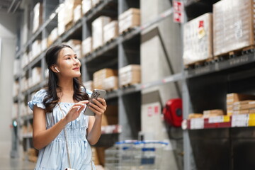 asian woman using smartphone in warehouse section of store