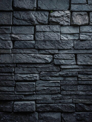 Dark grey stone wall texture with rough, irregular blocks.