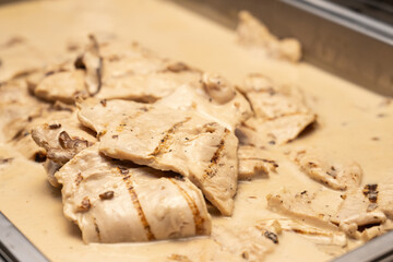 Grilled chicken in mushroom sauce is thin sliced and ready for the guests to eat