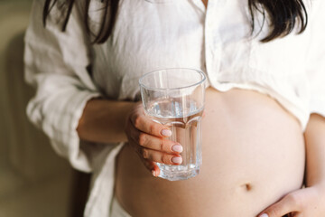 Pregnant drink water. Beautiful pregnancy drinking water. Happy pregnant woman holding glass of water. Pregnancy and Health Concept, maternity.