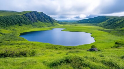 Obraz premium Serene mountain lake nestled in a valley. Lush green meadows surround a tranquil body of water