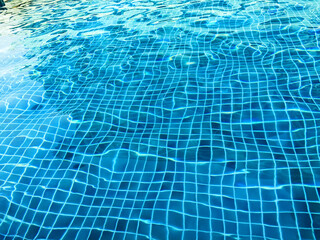 Swimming pool texture and surface water on pool, or water in the pool background with sun reflection.