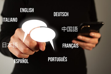 A person is pointing at a phone with a screen that has many foreign languages on it. The person is trying to communicate with someone who speaks a different language
