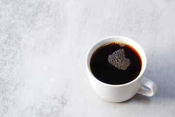 朝のひと時、お気に入りのマグカップに淹れたての美味しいコーヒーを入れて、ひと休みしているイメージ
