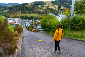 hiker girl walking up the Baldwin Street - the steepest street in the world located in Dunedin, Otago, New Zealand South Island