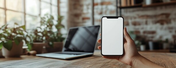 Close up of male hands holding smartphone with blank screen in modern workspace