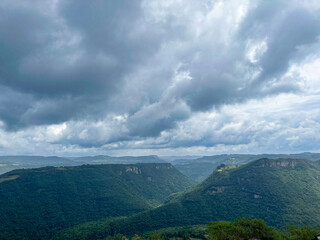 Obraz premium Scenic landscape of lush green mountains under a dramatic cloudy sky in southern Brazil, showcasing natural beauty and atmospheric weather