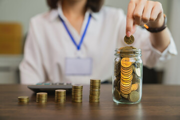 Tax concept, businesswoman and stacked coins in a glass.