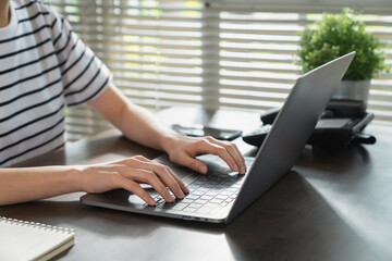 Hands typing keyboard on laptop with working online