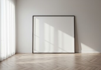 Fototapeta premium Large blank framed poster leaning against a white wall with sunlight and wooden floor visible