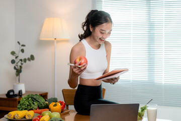 Nutritionist writing healthy eating plan sitting at desk with fruits and vegetables